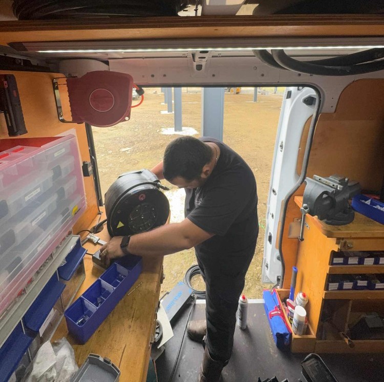 jeremi entrain de sertir un flexible dans son camion atelier qui sert pour les dépannages et entretiens sur site